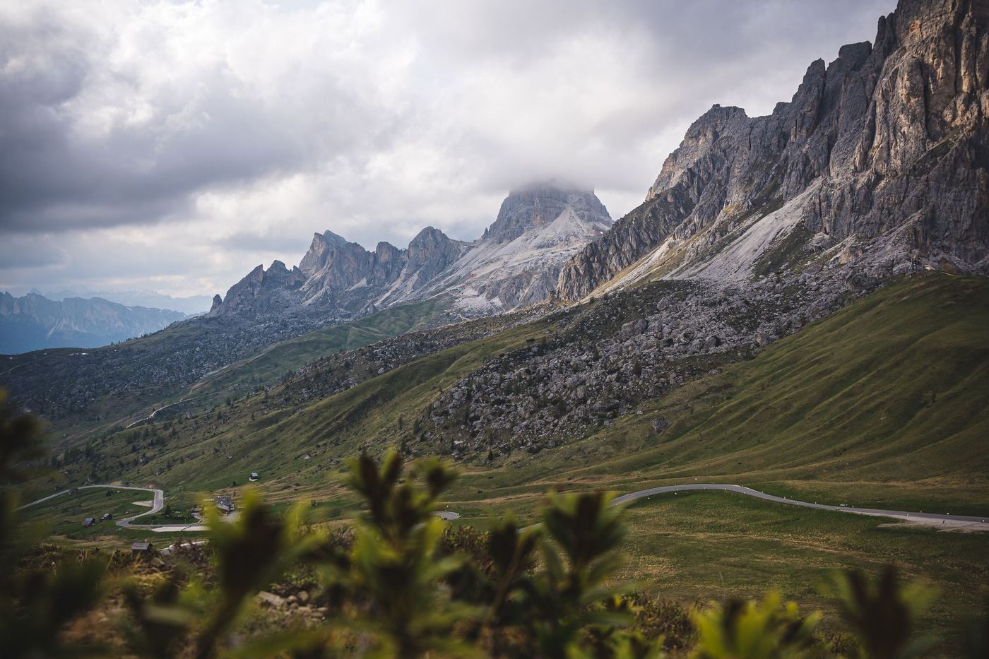 A mountain road climbing through an alpine pass beneath jagged peaks